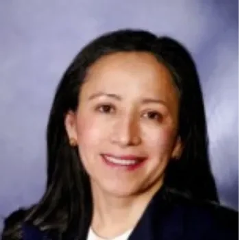 A woman with long hair and wearing a suit.